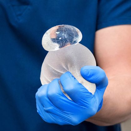 Surgeon squeezing ruptured breast implant